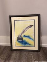 Full view of the framed painting showing the feather in ink bottle with yellow and blue background.