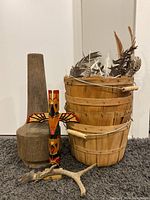 Wood baskets with a wooden totem pole, tall wooden pestle or mortar, and an antler on carpeted floor