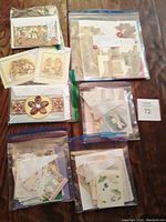 Overview of the seven packages of vintage Victorian scrapbook diecuts in plastic bags arranged on a table