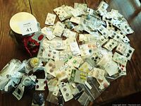 Overview of many vintage buttons in plastic bags and on cards with some vintage containers visible.