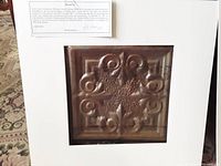 Tin ceiling tile with raised scroll and star design inside white matte with provenance certificate.