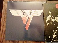 Close-up of Van Halen LP album cover featuring the iconic Van Halen wings logo in beige and red tones on black background.