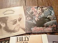 Top view of two LP album covers featuring Elton John Greatest Hits and Gerry Rafferty City to City.