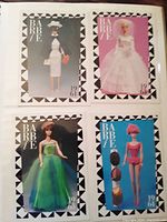 Four Barbie trading cards featuring dolls in vintage outfits from 1961 and 1963, including white bridal dress, green gown, and pink swimsuit.