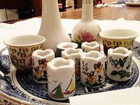 Miniature candle holders, two small cups, two miniature vases, and Blue Willow plate viewed from front