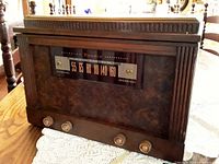 Front view of vintage Benedix wooden radio cabinet showing wood grain finish, radio tuning window with frequency numbers, and four control knobs on the front panel.