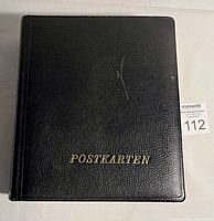 Front cover of the black leather-bound postcard album with gold lettering 'POSTKARTEN'