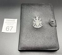 Closed black leather fold-over case featuring silver Royal Canadian Mint crest and number 1971 on spine