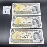 Front side photo showing 3 Canadian $1 bills from 1973 with serial numbers BCN5885616, BCN5885617, BCN5885618