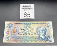 Front side of 1979 Canadian $5 bill showing portrait of Wilfrid Laurier and Canadian coat of arms.