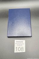 Closed navy blue hinged case containing the coin set, showing minimal wear.