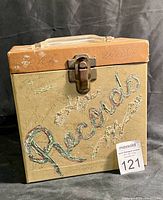 Front view of vintage portable record case with 'Records' written on front in decorative text and scribbles.
