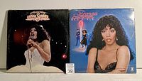Front view of two Donna Summer LP records side by side: 'Live And More' showing Donna Summer performing live, and 'Bad Girls' featuring a portrait of Donna Summer.
