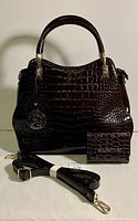 Front view of brown faux alligator skin handbag with matching wallet and detachable strap on white background.