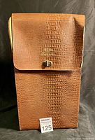 Front view of the brown faux alligator textured Safari carry case, showing the flap, gold turn-lock clasp, and alligator embossing pattern.