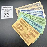 Batch of 10 banknotes displayed in fan arrangement showing Chinese, Korean, and Japanese currency