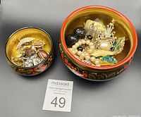 Two open hand-painted wooden boxes showing assorted costume jewelry inside