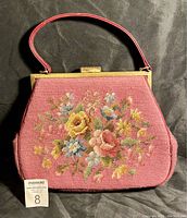 Front view of the vintage needlepoint handbag with floral design and metal frame.