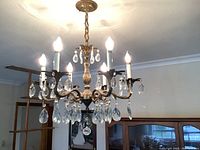 Front view of chandelier showing six arms with hanging prisms