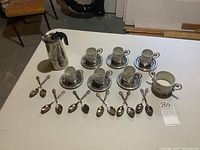 Full lot overview with 6 espresso cups in holders, 12 spoons, open sugar bowl, and 6-cup Moka pot displayed on table.