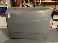 Gray Karrite Voyager cargo box closed, showing outer shell and logo.