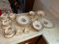 View of entire set including plates, bowls, cups, cream, and sugar on countertop