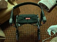 Top-down view of four-wheel walker showing padded handles and wheels.