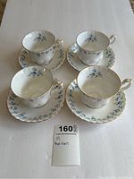 Full set of four Royal Albert Memory Lane teacups with matching saucers arranged on a white surface, showing overall condition including visible crazing on cups and saucers.