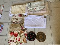 Top view of assorted folded table linens laid out on a surface, showing various colors, patterns, and sizes.