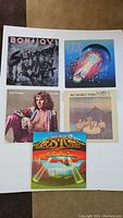 All 5 vinyl albums arranged on a white surface, showing front covers of Bon Jovi, Journey, Peter Frampton, Prism, and Boston albums
