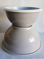 Two stacked mixing bowls showing the exterior beige color and the size difference between them.