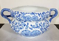 Front view of vintage ceramic jardiniere showing bulbous shape and detailed blue floral pattern.