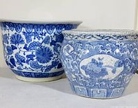 Two vintage blue and white Delft-style porcelain jardineres shown side by side on a white background.