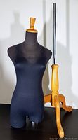Full view of black fabric covered dress form mannequin with wooden tripod base and turned wooden knob.