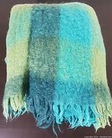 Folded view of vintage wool blanket showing fringe edge and color pattern