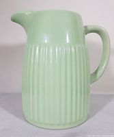 Front and side views of the mint green Typhoon stoneware pitcher showing ribbed detail and handle