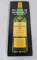 Front cover of the hardcover book showing a Glenlivet 12 year old single malt scotch whisky bottle on a black background with the title and author's name.