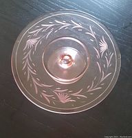 Top-down view showing the floral etched pink glass cake plate with pedestal base.