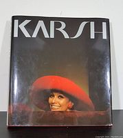 Front cover of the 1983 coffee table book "KARSH - A Sixty-Year Retrospective" featuring a color portrait of a woman wearing a red wide-brimmed hat and smiling.