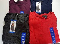 Four folded Buffalo David Bitton long sleeve knit tops in burgundy, navy blue, charcoal gray, and red with small hearts all size Large shown from above.