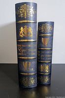 Two keepsake boxes styled as old books, with black covers and golden heraldic design and text referring to equestrian arts and sports.
