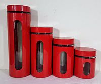 Set of four red cylindrical canisters with vertical clear windows and black lids in descending height order against white background