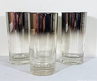 Four vintage hi-ball glasses displaying mercury fade from silver metallic to clear
