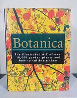 Front cover showing colorful fall foliage artwork and title text describing the illustrated A-Z guide for over 10,000 garden plants.