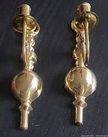 Two vintage solid brass wall mount candle holders, showing front view with decorative bulbous finial and candle cup