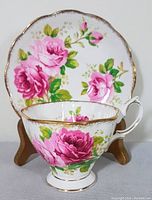 Front view of teacup and saucer with floral pattern and gold trim
