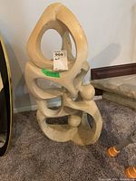 Front view of abstract stone sculpture showing cutout shapes and spheres