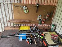 Wide shot of garden tools laid out on table with watering wands, pruning shears, ratchet set and gloves
