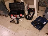 Photo of the open Jobmate black plastic toolbox, Mastercraft circular saw, Craftsman sander/polisher in case, Mastercraft cordless drill case on tile floor, showing all main items in the lot.