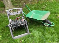 Wheelbarrow and hose reel caddy set on grass outdoors, showing overall condition and setup